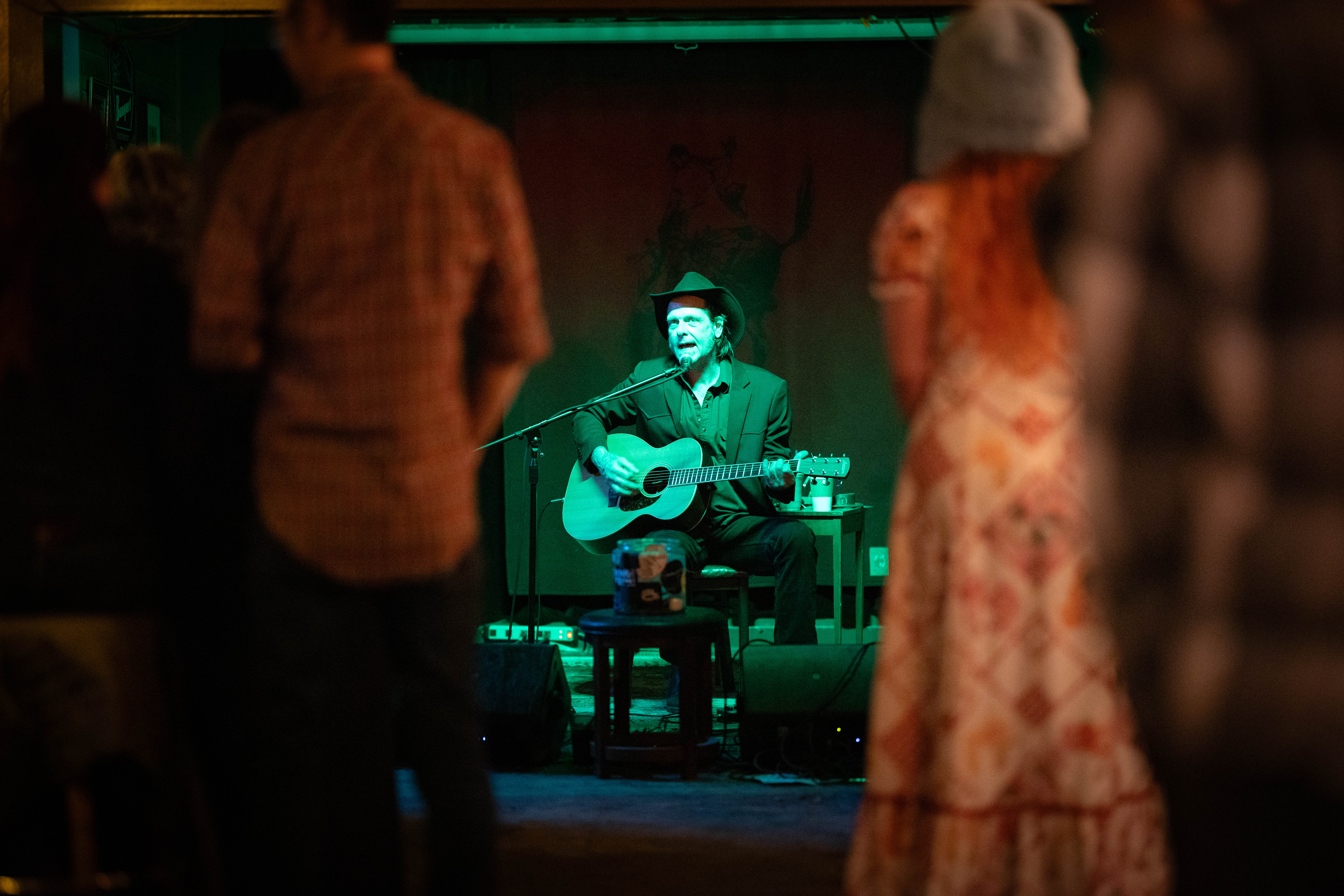 Green-lit portrait, intense performance moment
